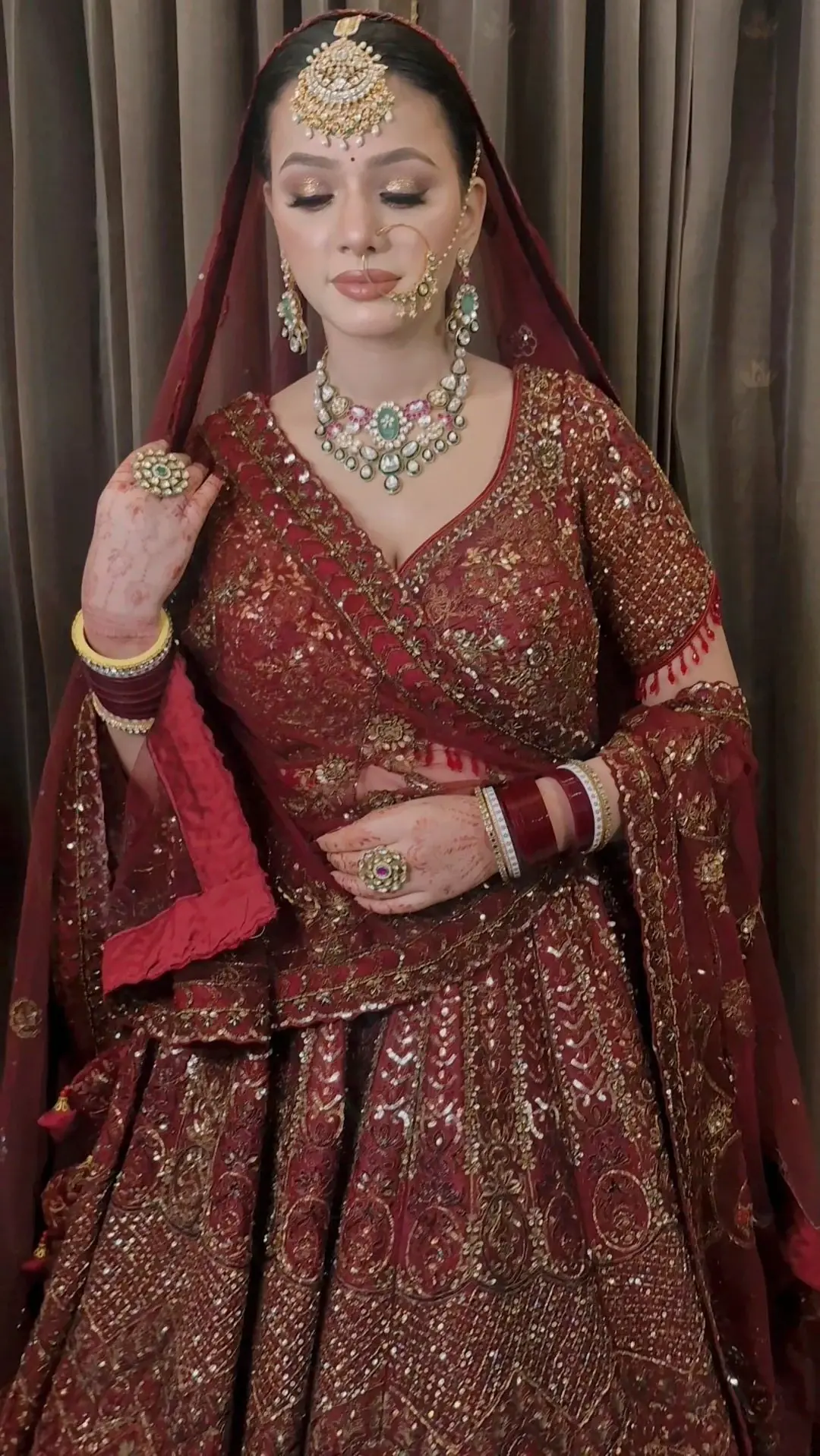 Indian bridal makeup with luminous skin, defined eyes and a refined red bridal look by Priyanshi in Roorkee